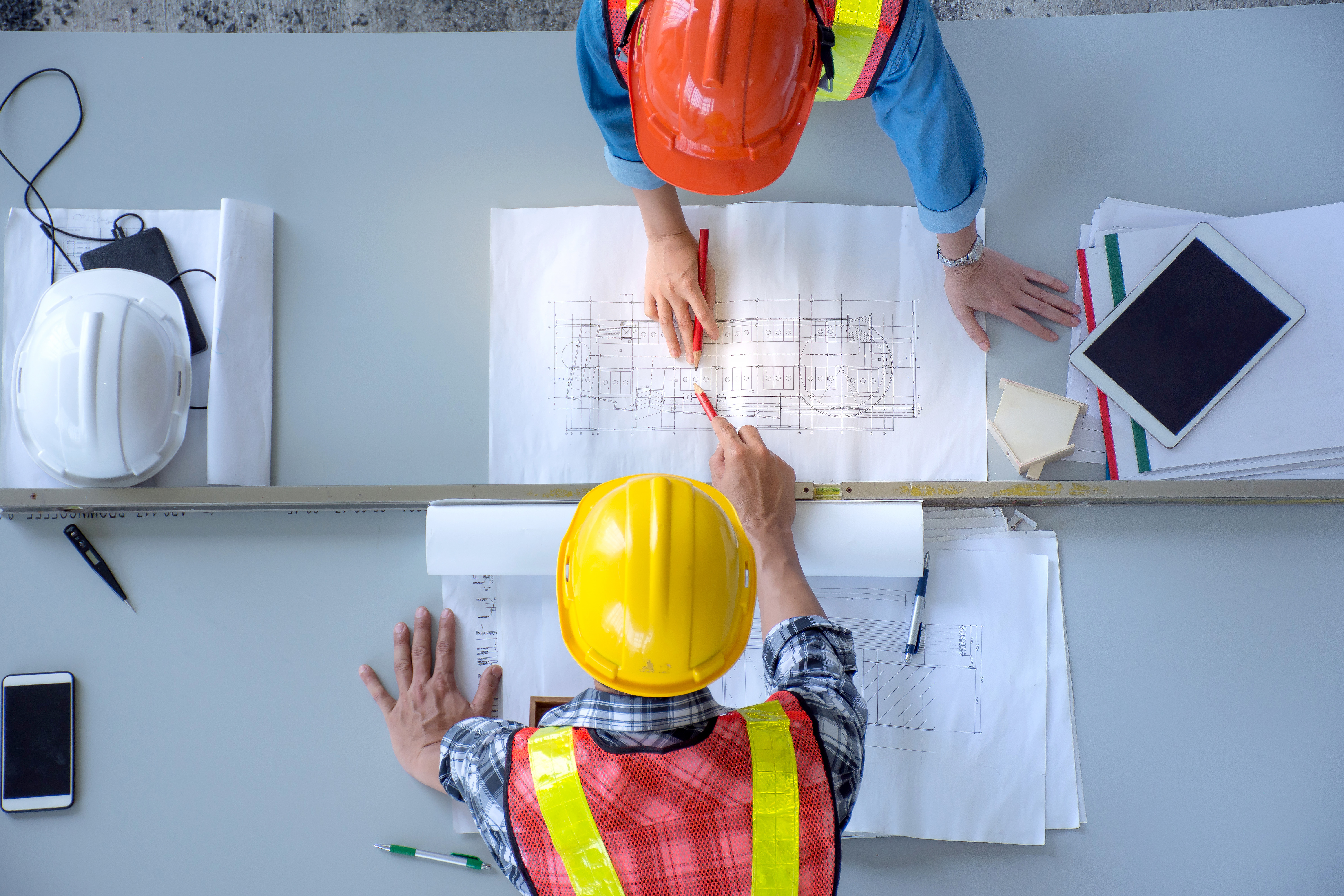 Twee bouwers bekijken samen een blueprint